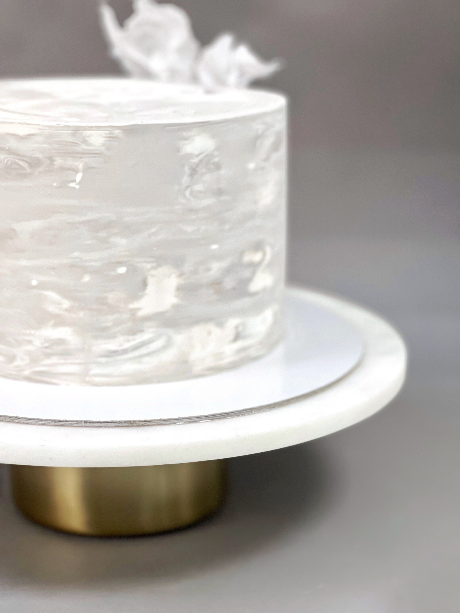 Close-up of a white cake with marbled frosting on a cake stand