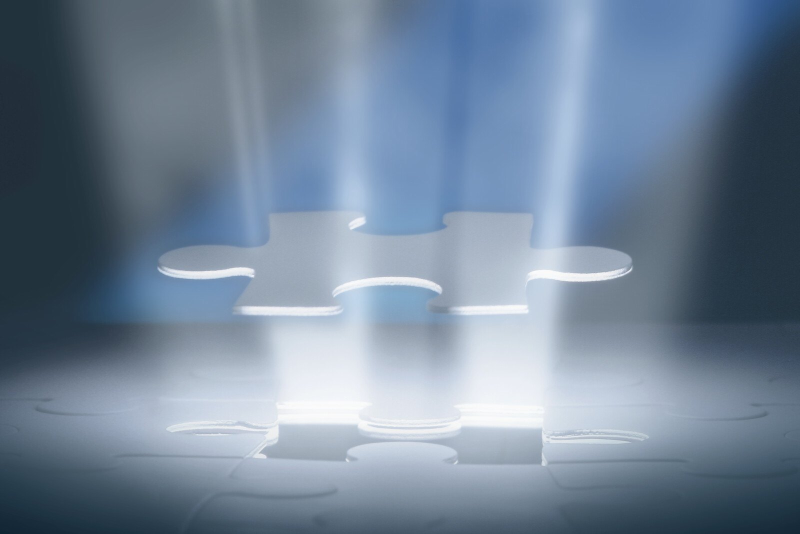 Glowing puzzle piece lifted above its empty slot with beams of blue light