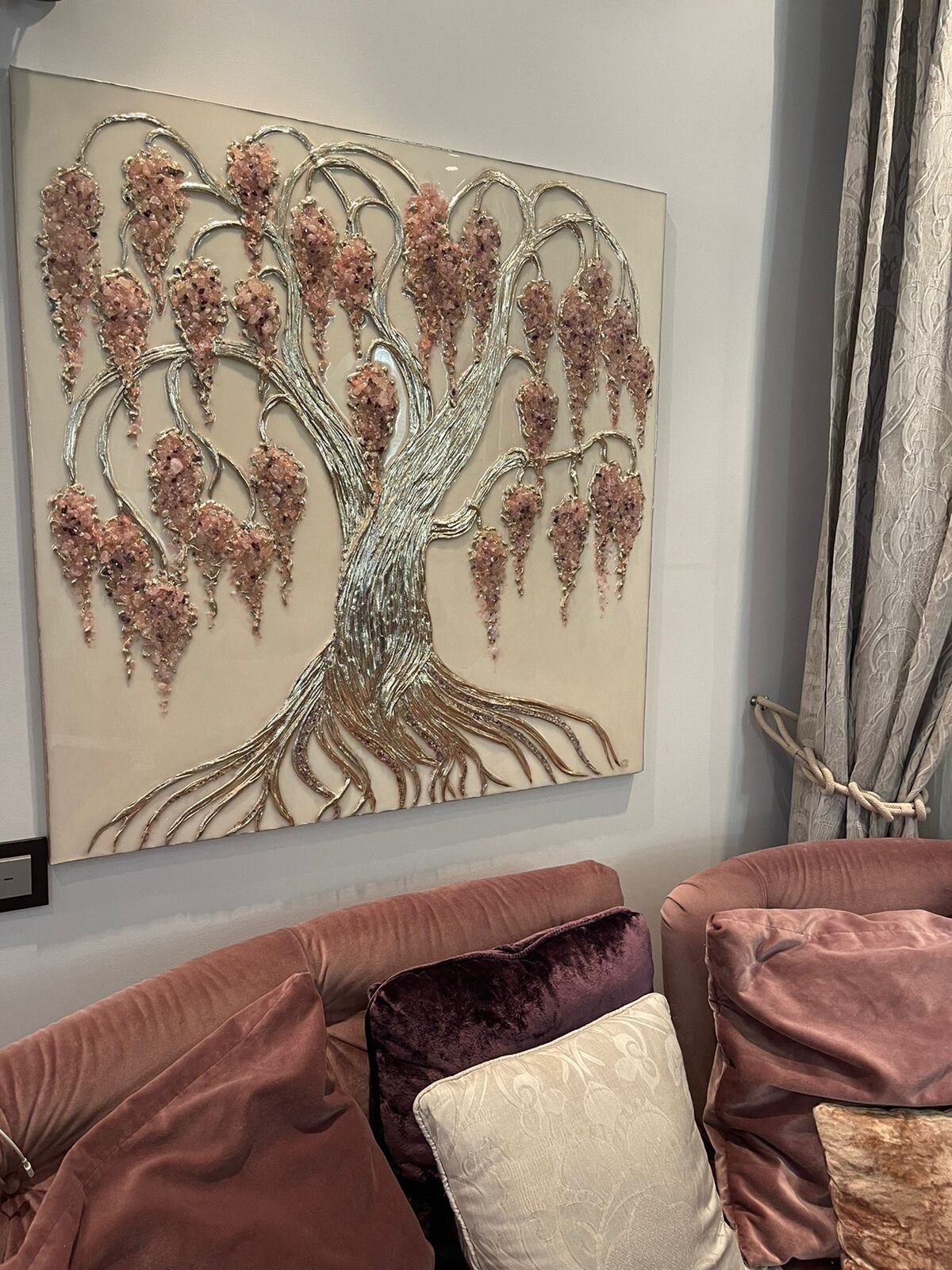 Silver and pink crystal weeping tree painting hanging above a pink velvet sofa