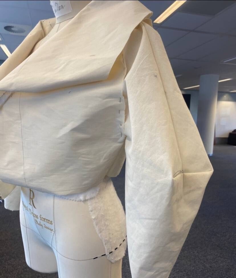 Side view of a muslin toile sleeve on a dress form