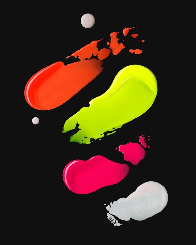 Neon orange, yellow, pink and white paint smears on a black background