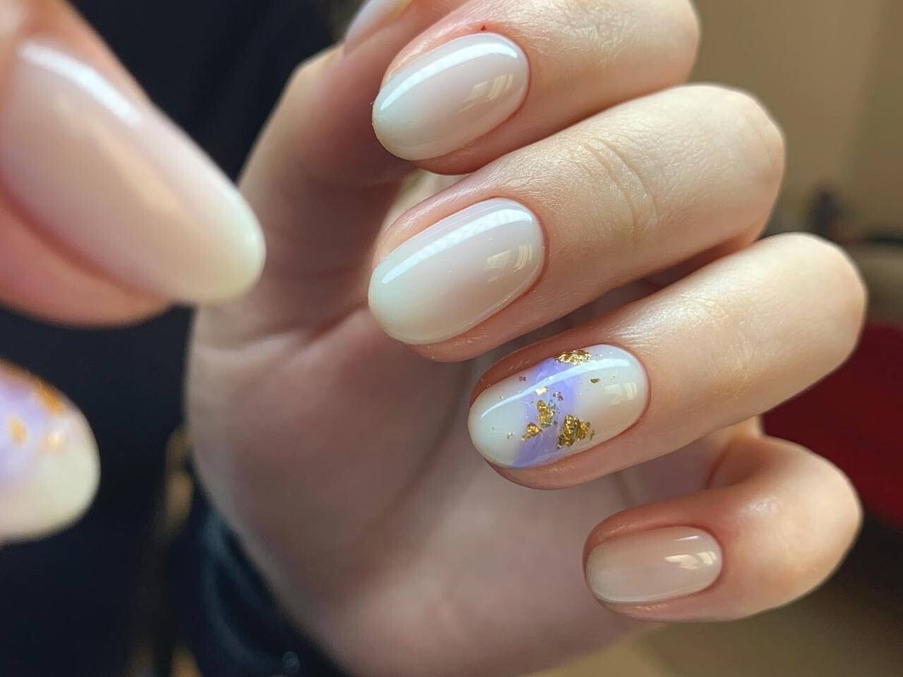 Hand with milky pink nails and a gold foil accent on one nail